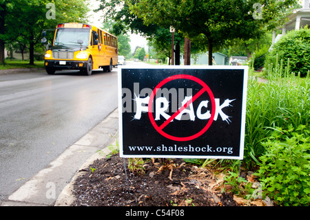 Anti fracking piastra in prato con giallo scuola bus in background, nello Stato di New York, Stati Uniti d'America Foto Stock