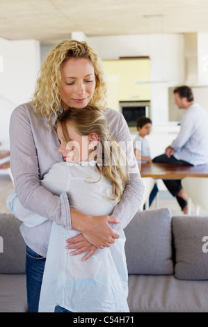 La madre abbraccia la figlia e sorridente Foto Stock