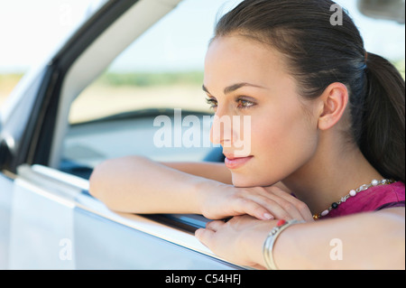 Giovane donna guardando fuori della finestra auto Foto Stock