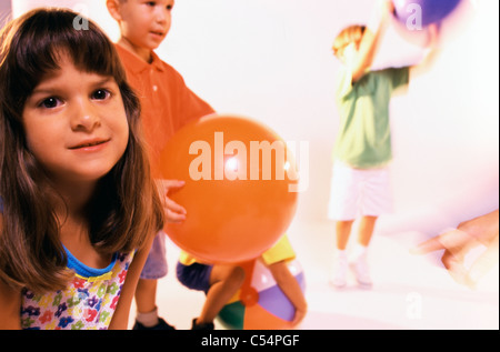 Bambini che giocano con le palle in una scuola materna Foto Stock