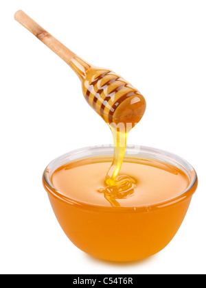 Ciotola di miele e di bastone di legno isolato su un bianco. Foto Stock