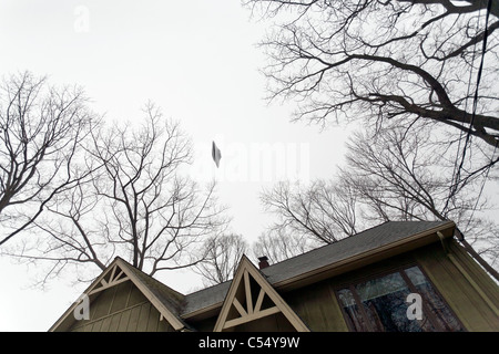 UFO volare al di sopra di una casa. Foto Stock