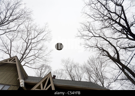 UFO volare al di sopra di una casa. Foto Stock