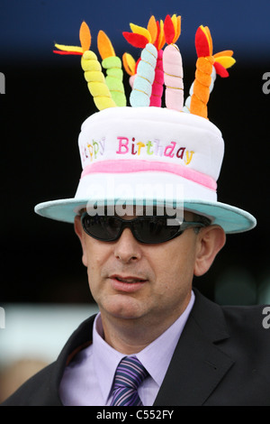 Uomo che indossa un cappello che assomiglia a una torta di compleanno, Ascot, Regno Unito Foto Stock