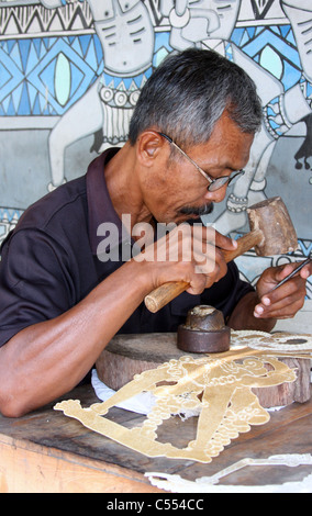 Un uomo giavanese creando un Wayang Kulit o tradizionale pupazzo di ombra. Foto Stock