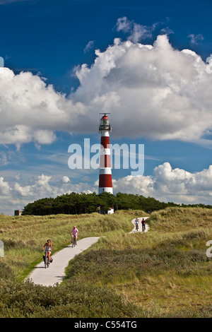 Holland, Ameland isola, il Wadden Sea Isole. Unesco - Sito Patrimonio dell'umanità. Faro. Persone di andare in spiaggia in bicicletta Foto Stock