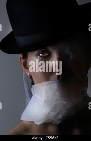 Donna avvolta in bende che indossa un cappello bowler Foto Stock