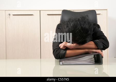 Business Woman in testa le mani sulla scrivania Foto Stock