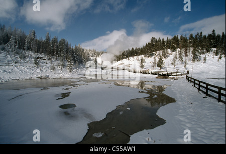 Staccionata lungo un lago ghiacciato, il Parco Nazionale di Yellowstone, Wyoming USA Foto Stock