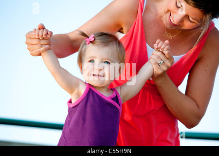 Donna aiutare la propria figlia a camminare Foto Stock