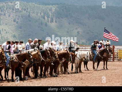 I partecipanti all'annuale Indian Rodeo tenutasi a Mescalero, Nuovo Messico, prua le loro teste mentre una preghiera viene letta su loudspeak Foto Stock