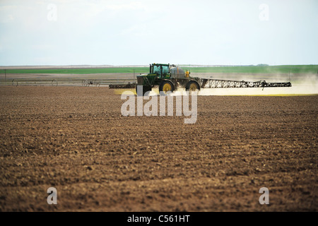 Un trattore che lavora in un campo di fattoria Foto Stock