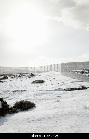 Dartmoor nella neve vicino a Saddle Tor con strada ghiacciata, Devon, Inghilterra, Regno Unito Foto Stock