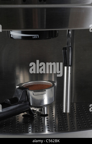 Portafiltro o portafilter casa espresso expresso maker riempito con caffè appena macinato e lancia vapore frother latte Foto Stock