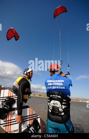Il kite surf istruttore tenendo il kite mentre dando lezioni in uno dei suoi clienti Foto Stock