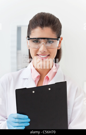 Sorridente fiducioso giovane dentista holding negli appunti Foto Stock