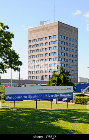 Basildon e Thurrock University Hospitals NHS Foundation Trust edificio alto prato in erba e cartello di benvenuto ospedale Basildon Essex Inghilterra Regno Unito Foto Stock