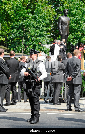Agente di polizia armato alla cerimonia di inaugurazione del Presidente Ronald Reagan statua in bronzo all ambasciata americana Grosvenor Square London street scene UK Foto Stock