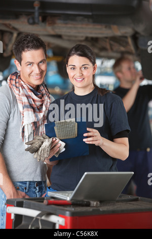 Ritratto di femmina lavoratore meccanico in piedi con il cliente Foto Stock