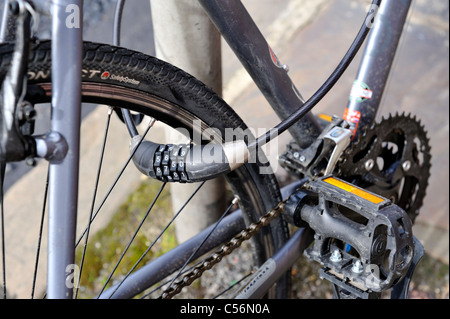 Bicicletta con la combinazione di blocco di sicurezza incatenato al post Foto Stock