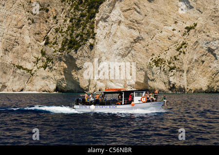 In barca a vela passato scogliere calcaree fuori da un'isola greca. Foto Stock