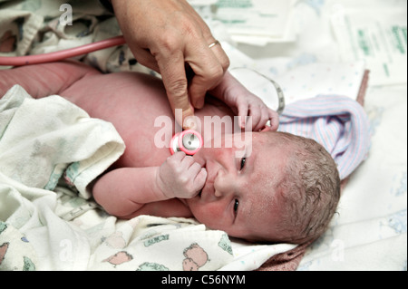 Neonato, ostetrica utilizzando uno stetoscopio Foto Stock