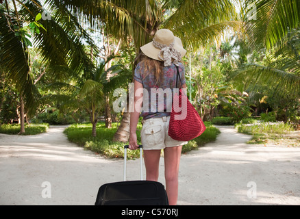 Donna valigia nel resort tropicale Foto Stock