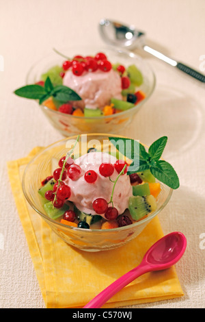 Macedonia di frutta con gelato allo yogurt. Ricetta disponibile. Foto Stock