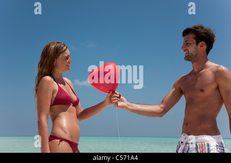 Accoppiare la condivisione di palloncino rosso sulla spiaggia Foto Stock