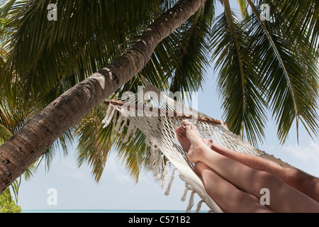 Giovane posa in amaca sotto il palm tree Foto Stock