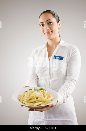 Donna in azienda identificativi piatto di pasta Foto Stock