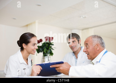 Medici e infermieri parlando in ospedale Foto Stock
