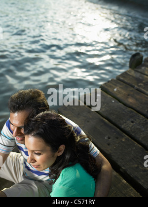 Giovane seduto sul dock insieme Foto Stock