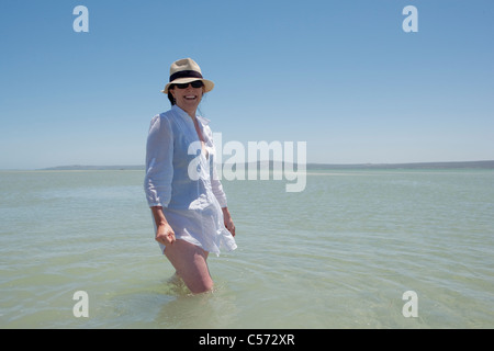 Donna anziana a piedi in acqua Foto Stock