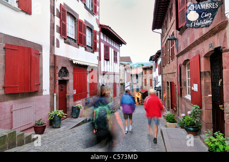 Francia, St. James titolo: Pellegrini passando lungo la Rue de la Citadelle in San Jean-Pied-de-Port Foto Stock