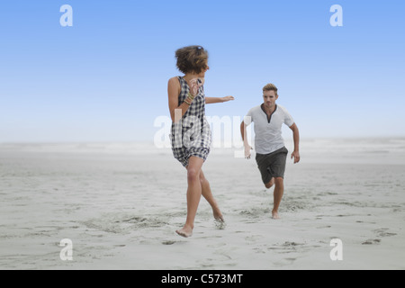 Giovane che si rincorrono sulla spiaggia Foto Stock