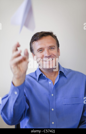 Imprenditore gettando aeroplano di carta Foto Stock