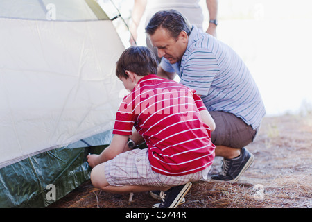 Padre e figlio pitching una tenda insieme Foto Stock