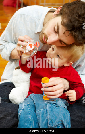 Padre e figlio a soffiare bolle insieme Foto Stock