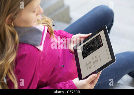 Vista ravvicinata di un Caucasian giovane donna a leggere 'un gioco di troni " libro da Kindle Ipad 2 applicazione Foto Stock