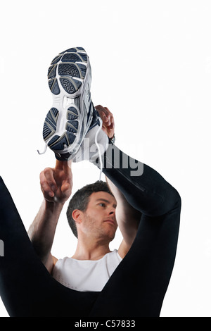 Uomo a mettere su scarpe da corsa Foto Stock