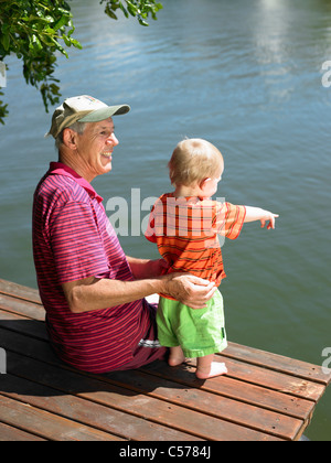 Uomo con il nipote sul pontile sul lago Foto Stock