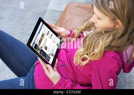 Chiudere l immagine di una giovane donna a leggere 'Dolce e Gabanna' Facebook Fan della pagina su un iPad 2 Foto Stock