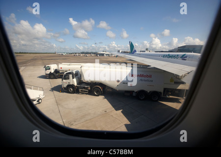 Guardando dalla Exxon mobil jet fuel cisterne di rifornimento di fare rifornimento di carburante un air canada 737 aerei passeggeri all'aeroporto di Dublino Foto Stock