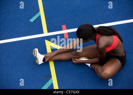 Runner stiramento sulla via Foto Stock