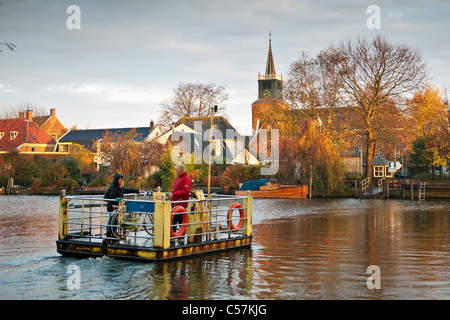 I Paesi Bassi, Nigtevecht, motore traghetto per passeggeri in piedi e biciclette attraverso il fiume Vecht. Traghetto chiamato Kantje Boord. Foto Stock