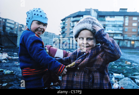 Bambini sotto forma di Transilvania città mineraria di Petrila in Romania giocano allegramente nel fango e immondizia disseminata strade 1994 Foto Stock