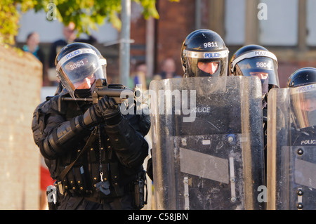 Funzionario di polizia mira a Heckler e Koch L104A1 37mm single-shot AEP launcher a rivoltosi Foto Stock