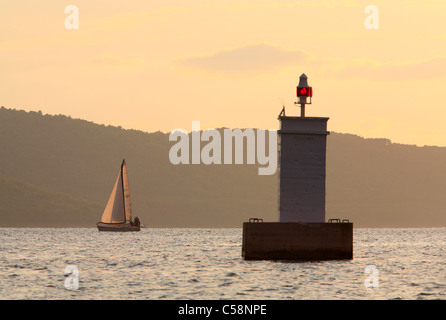 Faro e barca a vela Foto Stock