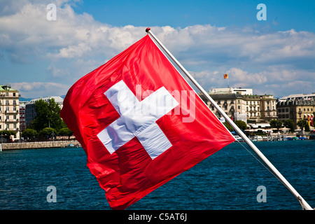 Una bandiera svizzera volare a poppa di un sistema per la cottura a vapore sul lago di Ginevra in Svizzera Foto Stock